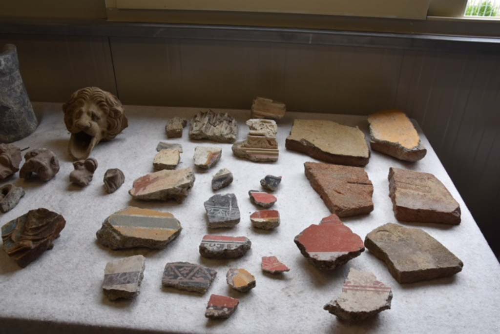 Regio V Pompeii. June 2018. Items found during the 2018 excavations. 
An unexpected aspect of the archaeological investigations carried out so far has been the discovery of a great number of finds, such as antefixes and clay decorations, fragments of frescoes and stuccos, fragments of amphorae and bricks, in the earth from the nineteenth century excavations and twentieth century carried out in the vicinity. 
Probably at the time there had been no interest in the recovery of fragmented or objects that were deemed unable to be reconstructed, which were therefore discarded.
See PAP: new-excavations-in-regio-v
Un aspetto inatteso delle indagini archeologiche finora condotte è stato il rinvenimento di un gran numero di reperti, quali antefisse e decorazioni fittili, frammenti di affreschi e di stucchi, frammenti di anfore e mattoni bollati, nella terra di risulta proveniente dagli scavi ottocenteschi e primo-novecenteschi svolti nelle adiacenze. 
Probabilmente all’epoca non c’era stato interesse al recupero di oggetti frammentari o non ricostruibili, che venivano pertanto scartati.
Vedi PAP: i-nuovi-scavi-della-regio-v
Photograph © Parco Archeologico di Pompei.