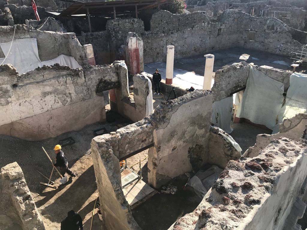 V.3 Pompeii. Casa del Giardino. 2018. Entrance from the Vicolo dei Balconi
Front. Fauces, ambiente 8 and ambiente 7.
Ambiente 5 atrium with portico 10 right and garden. 
Ambiente 3 behind atrium. Ambiente 1 to right.
The housing complex had its main access from the Vicolo dei Balconi, through a monumental door with two capitals "dice shaped" and a masonry frame; the narrow entrance led to an atrium (ambiente 5), in turn communicating with a portico (ambiente 10) opening onto the garden and supported by masonry columns, resting on a plinth decorated with frescoes on a black background depicting flowering plants.
Ingresso dal Vicolo dei Balconi
Davanti. Fauces, ambiente 8 e ambiente 7.
Dietro ambiente 5 atrio, con portico 10 a destra e giardino.
Ambiente 3 dietro l'atrio. Ambiente 1 a destra.
Il complesso abitativo aveva il suo accesso principale dal vicolo dei Balconi, attraverso una porta monumentalizzata da due capitelli “a dado” e da una cornice in muratura; lo stretto ingresso immetteva in un atrio (ambiente 5), a sua volta comunicante con un portico (ambiente 10) aperto sul giardino e sostenuto da colonne in muratura, poggianti su una zoccolatura decorata da affreschi su fondo nero raffiguranti piante fiorite.
http://pompeiisites.org/wp-content/uploads/Cartella-stampa-visita-Ministro-2.pdf
Photograph © Parco Archeologico di Pompei.