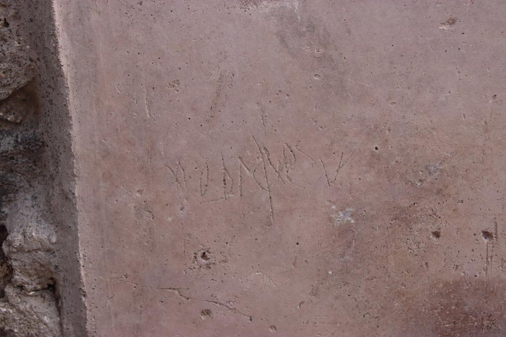 V.3 Pompeii. Casa del Giardino. October 2022. 
Graffiti on south (right) wall of entrance doorway/corridor/fauces, on the same wall below the graffiti in the photo above.
Photo courtesy of Klaus Heese.
