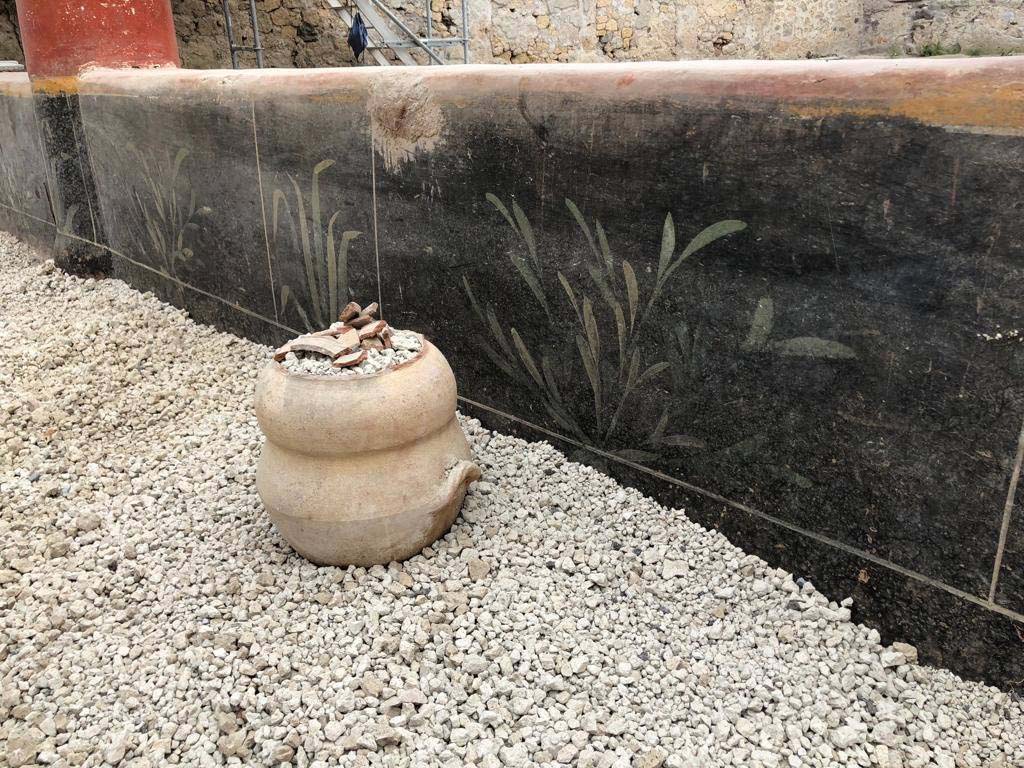 V.3 Pompeii. Casa del Giardino. 2018. The portico has a low black wall with plant decoration and red and white columns.
Il portico ha una parete nera bassa con decorazione vegetale e colonne rosse e bianche.
Photograph © Parco Archeologico di Pompei.