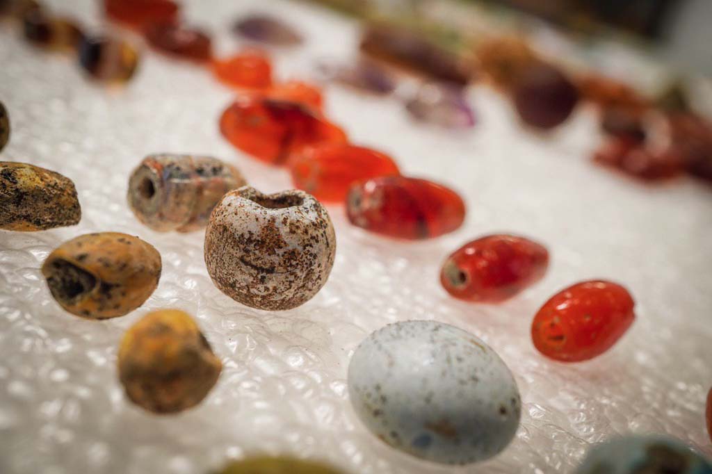 V.3 Pompeii. Casa del Giardino. August 2019. Amber, glass and other gems, apparently part of a necklace.
Ambre, vetri e altre gemme, appartenevano una collana.
Photograph © Cesare Abbate/ANSA courtesy Parco Archeologico di Pompei.