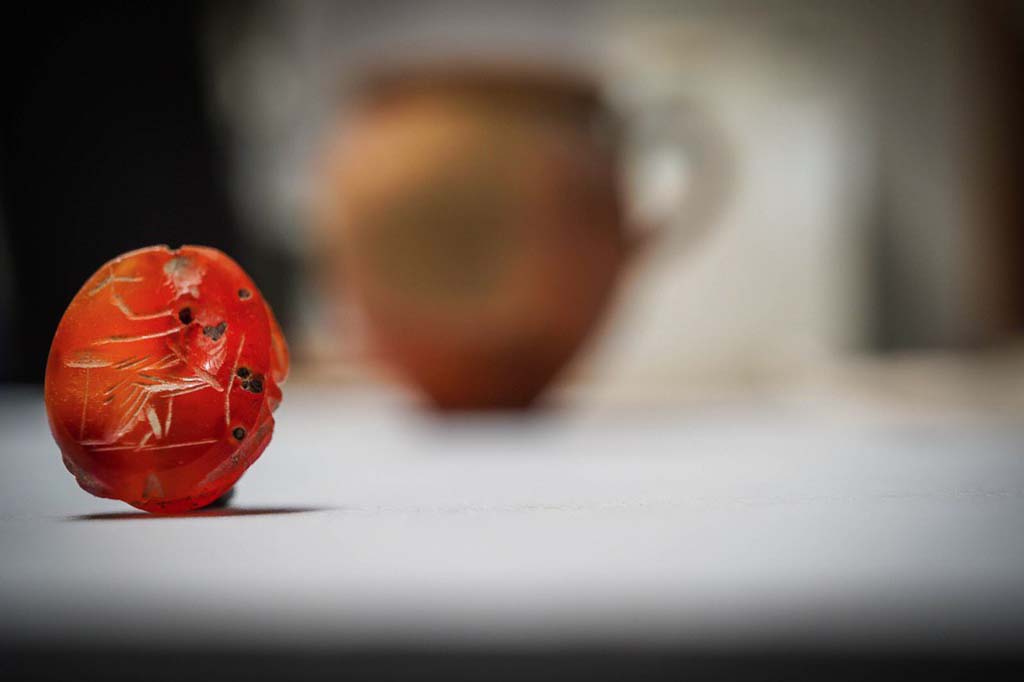 V.3 Pompeii. Casa del Giardino. August 2019. An engraved carnelian.
                                                           
Una corniola incisa.
Photograph © Cesare Abbate/ANSA courtesy Parco Archeologico di Pompei.