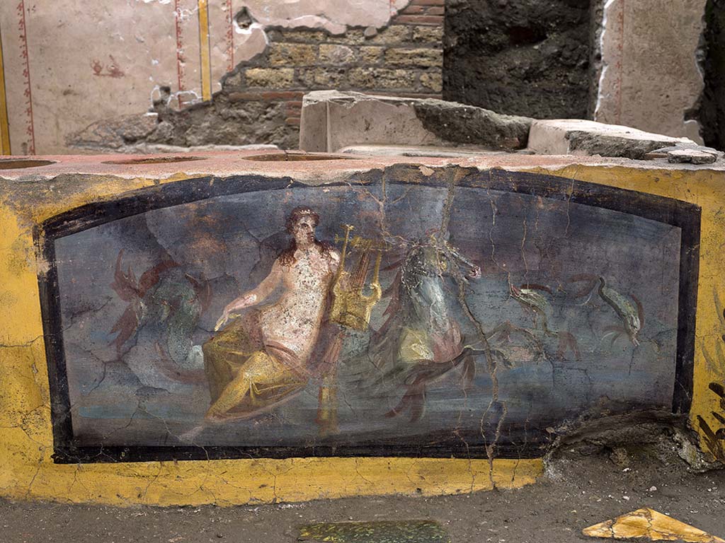 V.3 Pompeii, Thermopolium with painting of nereid. December 2020.
The decorations on the counter - which were the first to emerge during the excavation – show on the front, longer side, the image of a Nereid riding a horse in a marine setting.
V.3 Pompei, Termopolio con dipinto di nereide e anfore. Dicembre 2020.
Le decorazioni del bancone - le prime emerse dallo scavo - presentano sul fronte, lato più lungo, l'immagine di una Nereide a cavallo in un ambiente marino.
Photo by Luigi Spina courtesy of Parco Archeologico di Pompei.
