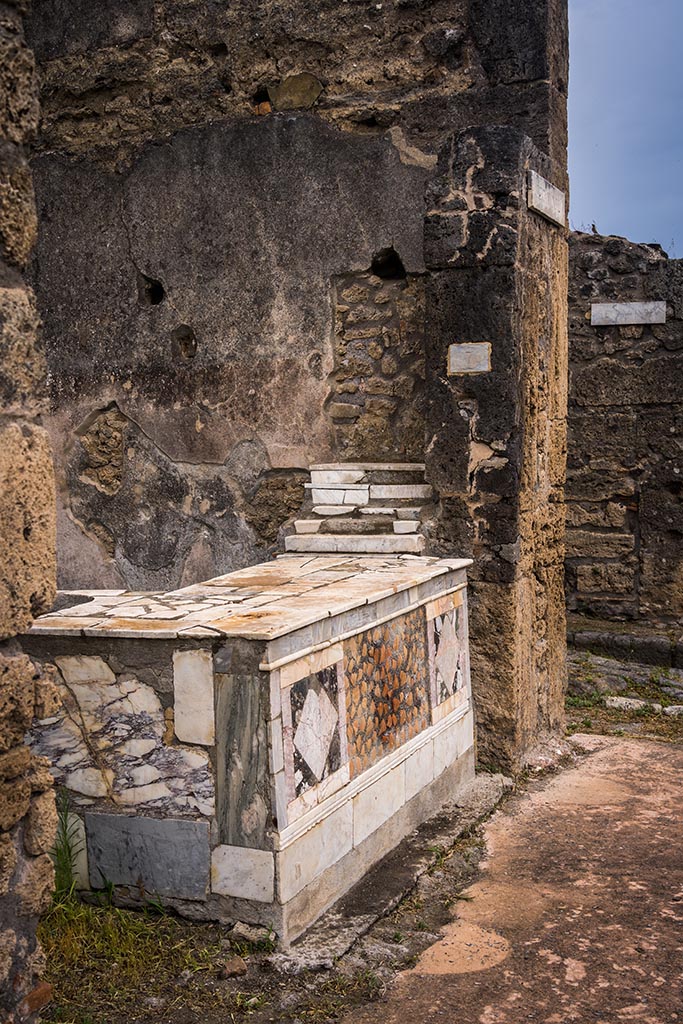 V.4.7, Pompeii. July 2024. 
Looking east along counter towards shelving and east wall. Photo courtesy of Johannes Eber.