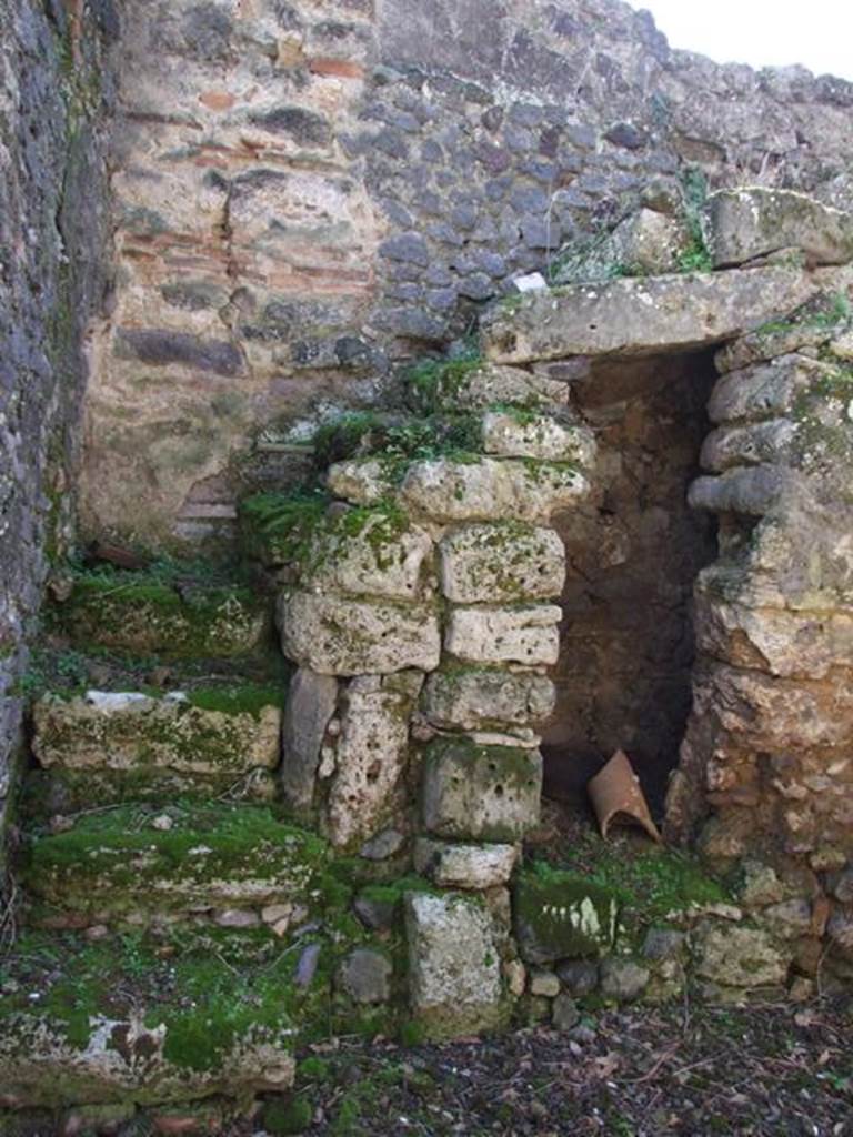 V.4.10 Pompeii.    March 2009.  Stairs to upper floor on south side of entrance fauces, and underneath Latrine with dog kennel?