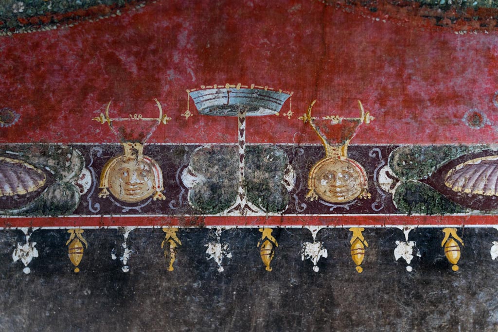 V.4.a Pompeii. January 2023. 
Room ‘h’, detail of painted decoration above black side panel on upper south wall at east end. Photo courtesy of Johannes Eber.