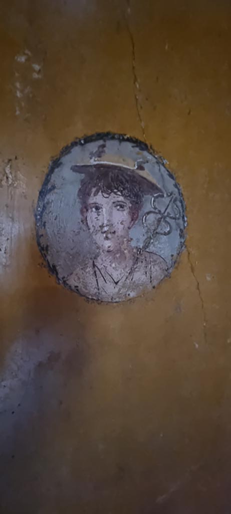 V.4.a Pompeii. January 2023.
Room ‘i’, medallion with painting of boy on west wall of cubiculum on north side of doorway to atrium. 
Photo courtesy of Miriam Colomer.