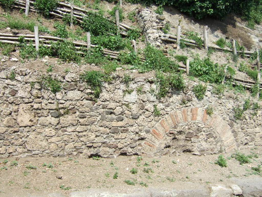 V.6.7 Pompeii. May 2006. Unexcavated façade, detail from south end.