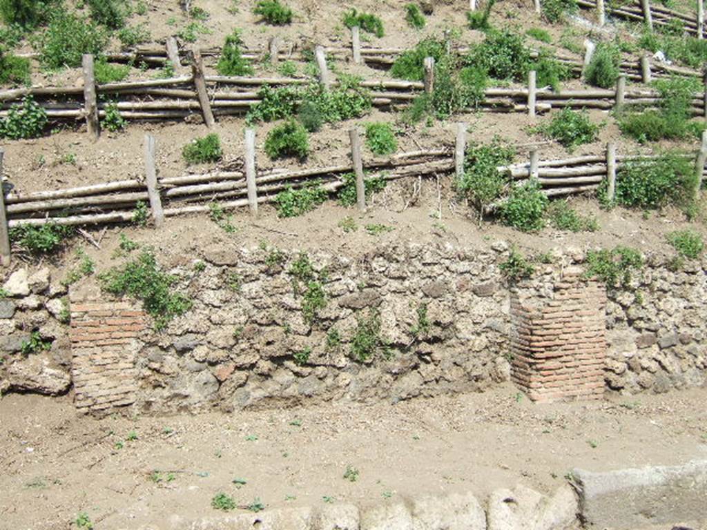 V.6.10 Pompeii, (in centre). May 2006. Unexcavated facade and entrance.
V.6.11, entrance doorway (on left), V.6.9 on right.