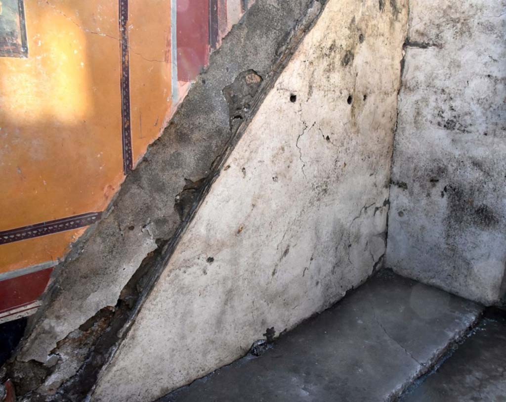 V.6.12 Pompeii. February 2019. Amb. 25. Atrium corner with outline of stairs. 
Of particular note in the atrium of Narcissus is the still visible trace of the stairs which lead to the upper floor, but above all the rediscovery of a dozen glass containers, eight amphorae and a bronze funnel in the space under the stairs, which was used for storage. 
Interessante, nell'atrio di Narciso, è la traccia ancora visibile delle scale che conducevano al piano superiore, ma soprattutto il ritrovamento nello spazio del sottoscala, utilizzato come deposito, di una dozzina di contenitori in vetro, otto anfore e un imbuto in bronzo.
Photograph © Parco Archeologico di Pompei.