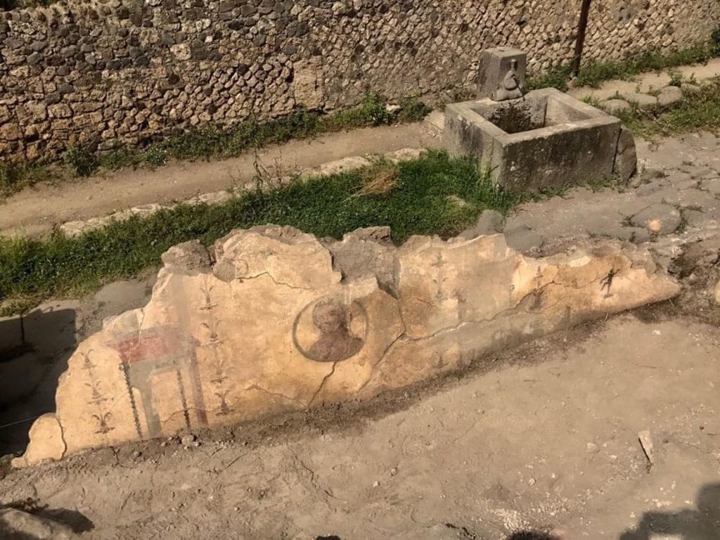 V.6.12 Pompeii. August 2018. Newly excavated west wall with architectural painting and portrait medallion.
La parete ovest recentemente scavata con pittura architettonica e medaglione ritratto.
Photograph © Parco Archeologico di Pompei.