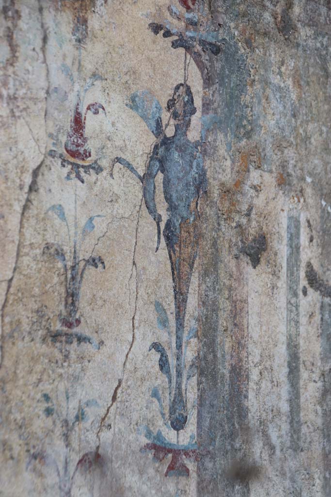 V.6.12 Pompeii, September 2021. 
Detail of painted floral decoration and figure at west end of centre of north wall. 
Photo courtesy of Klaus Heese.