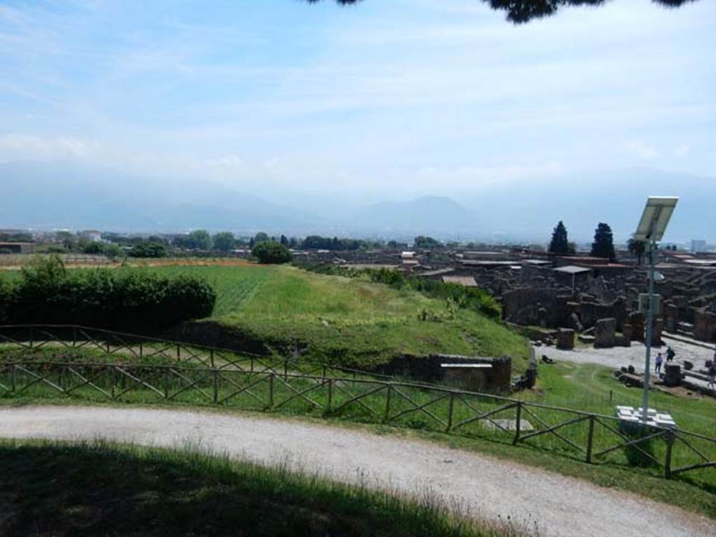 V.6.19 Pompeii. May 2015. Looking south across unexcavated area, with lararium painted on wall, in lower right. Photo courtesy of Buzz Ferebee.