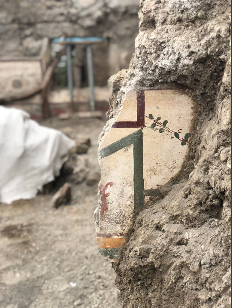 V.7.1 Pompeii. April 2018. Painted plaster on west wall of room with cupids.
Looking west to another room decorated with spiral designs and with a window onto the newly excavated north part of the Vicolo di Cecilio Giocondo.
Photograph © Parco Archeologico di Pompei.