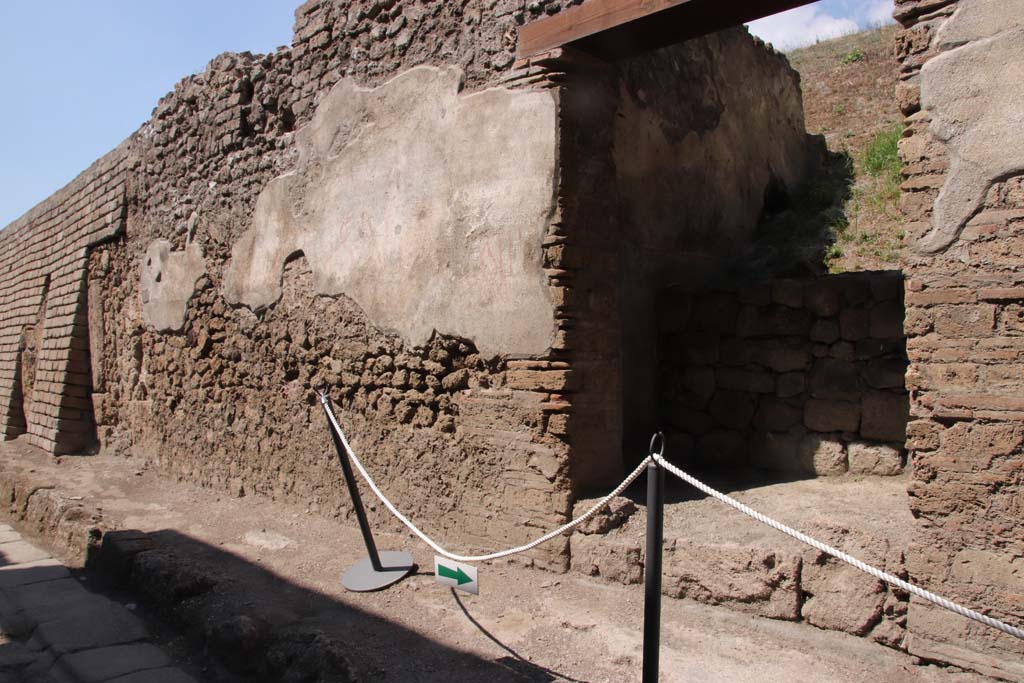 V.7.5, on left and V.7.6, on right, Pompeii. September 2021. 
Entrance doorway with remaining plaster with graffiti, looking west along north side of Vicolo delle Nozze d’Argento.
Photo courtesy of Klaus Heese.