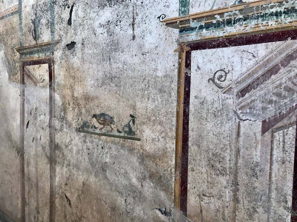 V.7.7 Pompeii. 2018. Room to the west of the entrance. East wall, centre, with painting of bird and fruit between architecture.
Photograph © Parco Archeologico di Pompei.