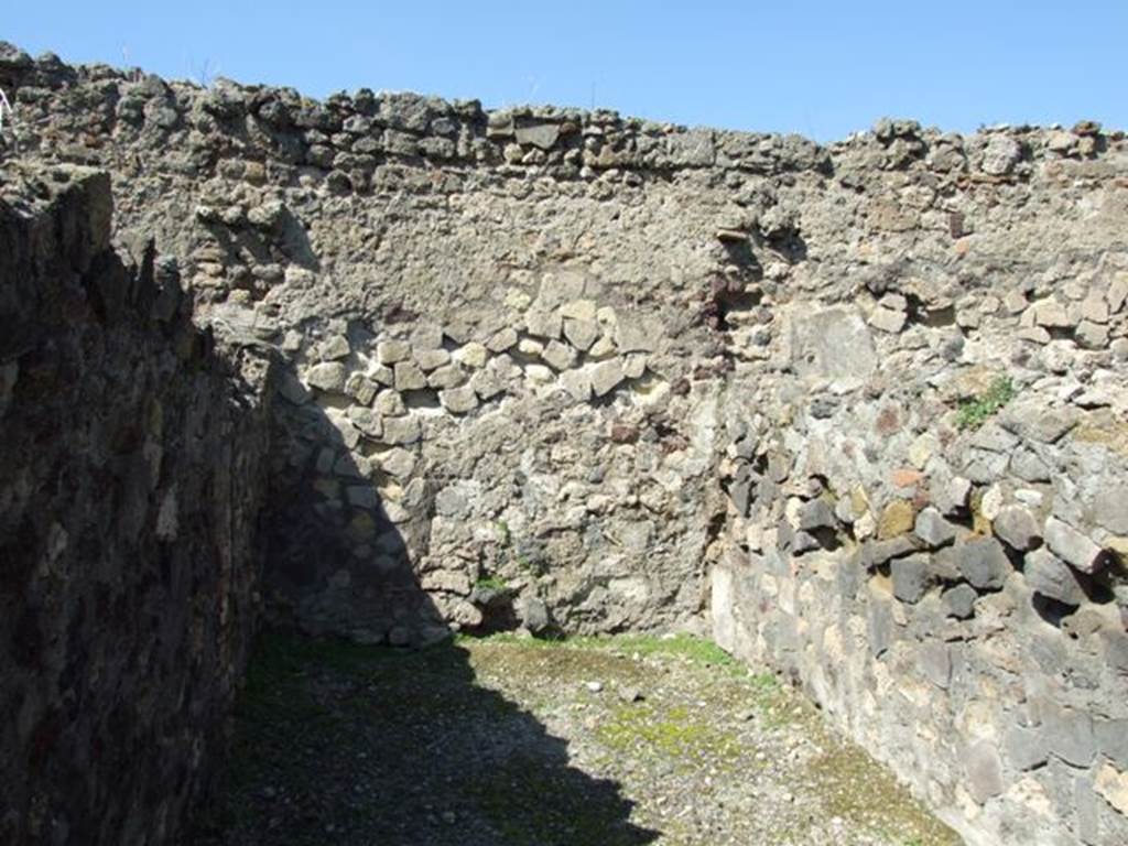 VI.1.2 Pompeii. March 2009. North wall of second room on north side. 
On the left, in the shadow, was the toilet. According to Hobson, later this toilet was overlaid by a floor to allow the ground floor rooms to be used as work areas. The sleeping and residential rooms were moved to the newly constructed upper storey, to which the toilet facility was also removed.  The down pipe from the upper storey which drained into the pit for this toilet was situated in a stone buttress on the northern aspect of the wall in VI.I.I, at the rear of this toilet.  The buttress was built above the entrance to the cesspit.  The excavation of the cesspit below the buttress, using long-handled tools, revealed a large amount of pottery, glassware, and some coins.  Fortunately this cesspit was only 2.5m deep and could be completely cleared.  It is possible that it had been used as a rubbish disposal pit, perhaps after the earthquake of 62CE. See Hobson, B., 2009. Latrinae et foricae: Toilets in the Roman World. London; Duckworth. (p.63)