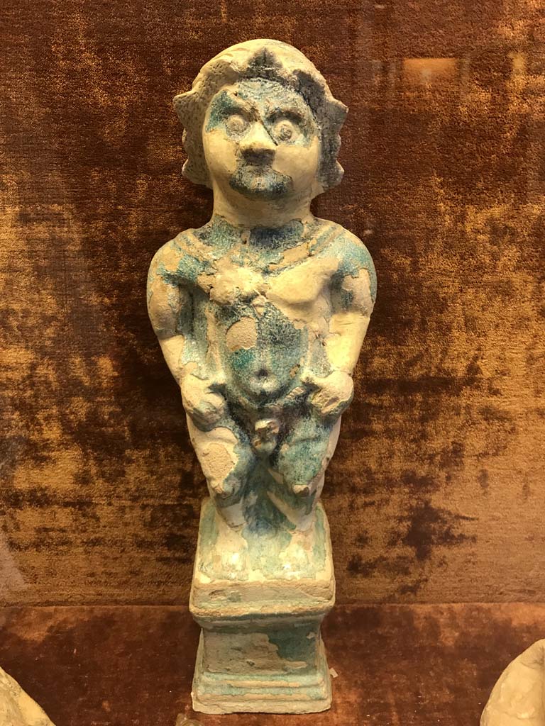VI.1.2 Pompeii. April 2019. Statuette of Ptah-Pateco found in VI.1.2 on 6th October 1770.
Photo courtesy of Rick Bauer.
Now in Naples Archaeological Museum.  Inventory number 22607.
Sala (room) 88, glass cabinet V, shelf A (bottom).
See Di Gioia, E. (2006). La ceramica invetriata in area vesuviana. “L’Erma” di Bretschneider, (p.110-111).