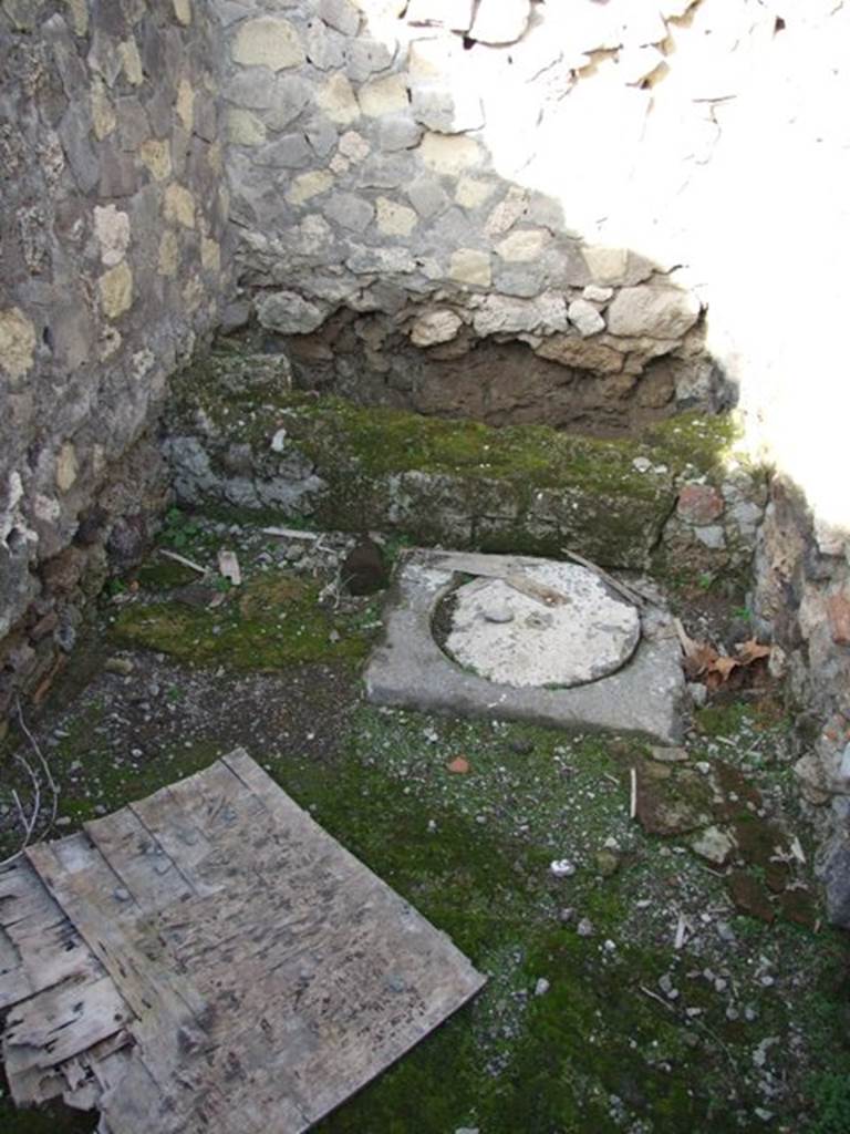 VI.1.7 Pompeii. December 2007 Room 5, latrine. The cesspit was situated vertically below the seat. There was a circular masonry lid in front of the toilet allowing visual access to the pit below, and probably enabling it to be emptied. See Hobson, B., 2009. Latrinae et foricae: Toilets in the Roman World. London; Duckworth. (p.62-3)