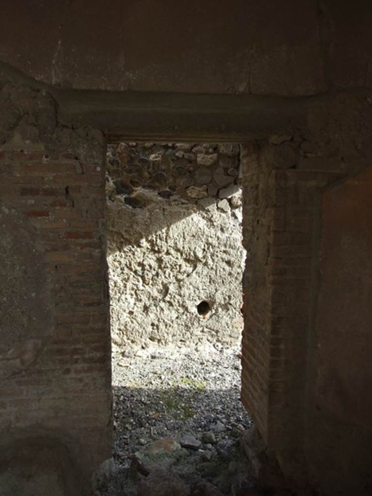 VI.1.7 Pompeii. December 2007. 
Doorway to room 24, services’ room for the baths area, in south-east corner of portico.
In the east wall, one of the two conduits acting as vents from the adjacent praefurnium can be seen.