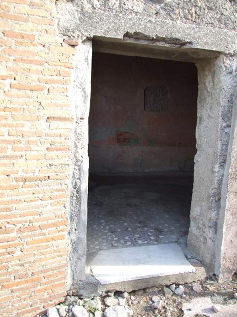 VI.1.10 Pompeii. December 2007. Doorway to room 9. Room to south of garden.  Mau identified the room at the rear, to the right of garden, with window opening onto the garden as the only room with paintings of interest:  A man sitting with a writing tablet in his hand, opposite him were 2 girls, one sitting, the other standing; the latter held a roll of papyrus, p.281, Same room, another panel, which was transferred to Naples Museum:  A young woman was represented as painting a herm of Dionysus; a cupid was holding the unfinished picture while she mixed colours on her palette. Two other maidens were watching the artist with unfeigned interest, etc , p.282, figure 133,                                       
The room contained a third picture, which is now almost obliterated.
See Mau, A., 1907, translated by Kelsey F. W. Pompeii: Its Life and Art. New York: Macmillan.  (p.280-2, T. 133).
Helbig identified:
Room to the right of the garden, God and 2 girls, 1459
Room near peristyle, Painting of Girl, 1443
Maybe in the prothyron, Bust of a Girl, 1427b
See Helbig, W., 1868. Wandgemälde der vom Vesuv verschütteten Städte Campaniens. Leipzig: Breitkopf und Härtel. (1459, 1443, 1427b).