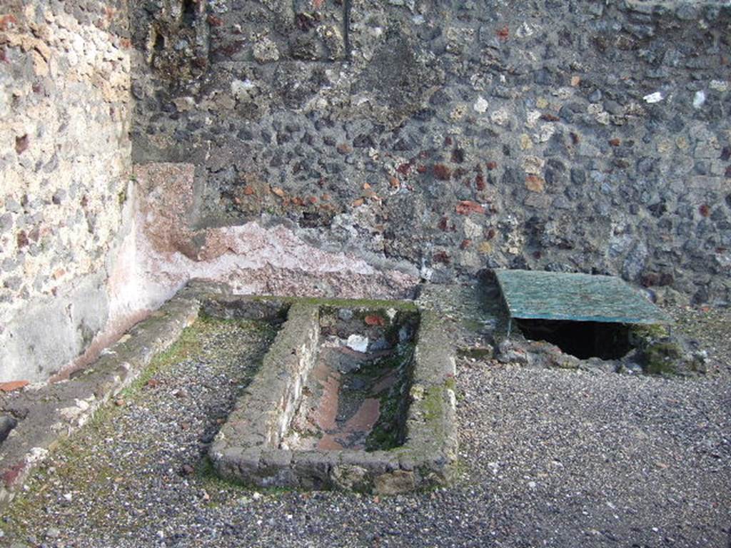 VI.1.15 Pompeii. December 2005. East wall with basins or vats.
According to Jones and Robinson, a group of small workshops were constructed in the south of the insula. Each workshop had a wide shop doorway opening onto Via Consolare. Plaster-lined tanks, similar to those found in the north of the insula, were recovered from the excavations of the Soap Factory (VI.1.14/15). They were also discovered at the Bar of Acisculus (VI.1.17) and also from the Shrine at VI.1.13. This suggested that there was a consistent phase of tank-centred industrial activity throughout the insula, and that fish processing was a major industry in this area of Pompeii during the late second and early first centuries BC.
See Dobbins, J & Foss, P., 2008. The World of Pompeii. New York: Routledge. (p.394)
On page 398, they say that following the Social War, the fish processing tanks were abandoned and the workshops redeveloped. In the Soap Factory, a group of clay and stone hearths were recovered, along with significant quantities of hammerscale, charcoal, slag and hearth bottoms.  This property was now operating as a metal smithy.