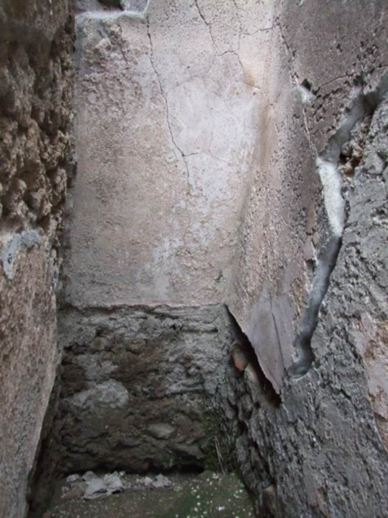 VI.2.10 Pompeii. December 2007. Latrine on east side of kitchen. According to Hobson, this shows the slots in the side walls together with the plastering covering the three walls down to the level of the seat. He thought that this showed that this latrine may have been at least comfortable, and may even have had decoration on the wall plaster. See Hobson, B., 2009. Latrinae et foricae: Toilets in the Roman World. London; Duckworth. (p.49)