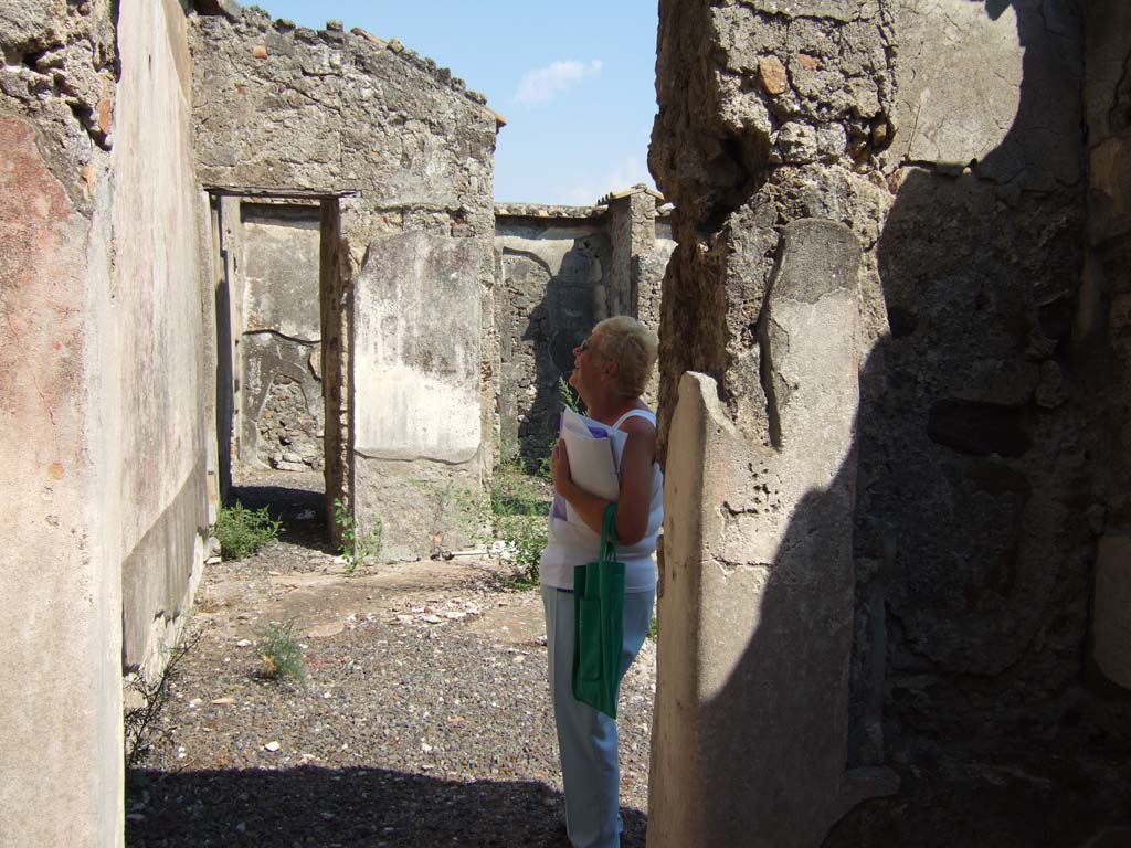 VI.2.14 Pompeii. September 2005. Looking east across north side of atrium, from room on north side of entrance fauces. 
Looking east towards a corridor to the garden area, on the north side of the tablinum.
