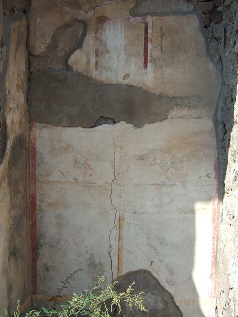 VI.2.14 Pompeii. September 2005. Tablinum, narrow north wall with remains of painted stucco.
The wall was divided into two areas by a painted candelabra, each of the two areas contained a painted panel.
On the east side the painted panel contained a painting of a cupid.
Although the colour of the north wall was completely faded, it was probably the same as the west wall with black zoccolo and middle zone, and white upper.
