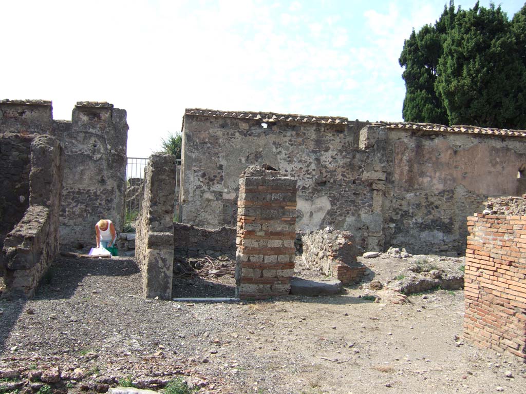 VI.2.17 Pompeii. September 2005. Looking west towards entrance corridor, and doorway to another cubiculum in north-west corner of atrium.
This cubiculum would have had a staircase on its northern side, with a lava base step. 
Adjacent to the steps would have been a passage leading to the kitchen and latrine.
Next to the passageway would have been an oecus.
This corner was badly affected by the 1943 bombing.