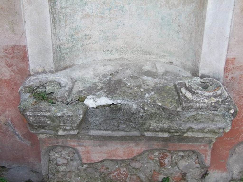 VI.2.22 Pompeii. December 2007. The base of the aedicula niche was painted red. The projecting ledge had three bands of stucco ornament , and two tall fluted columns rested on it. They supported the pediment. The columns and the pediment are now all vanished. See Boyce G. K., 1937. Corpus of the Lararia of Pompeii. Rome: MAAR 14.(142, p44).
