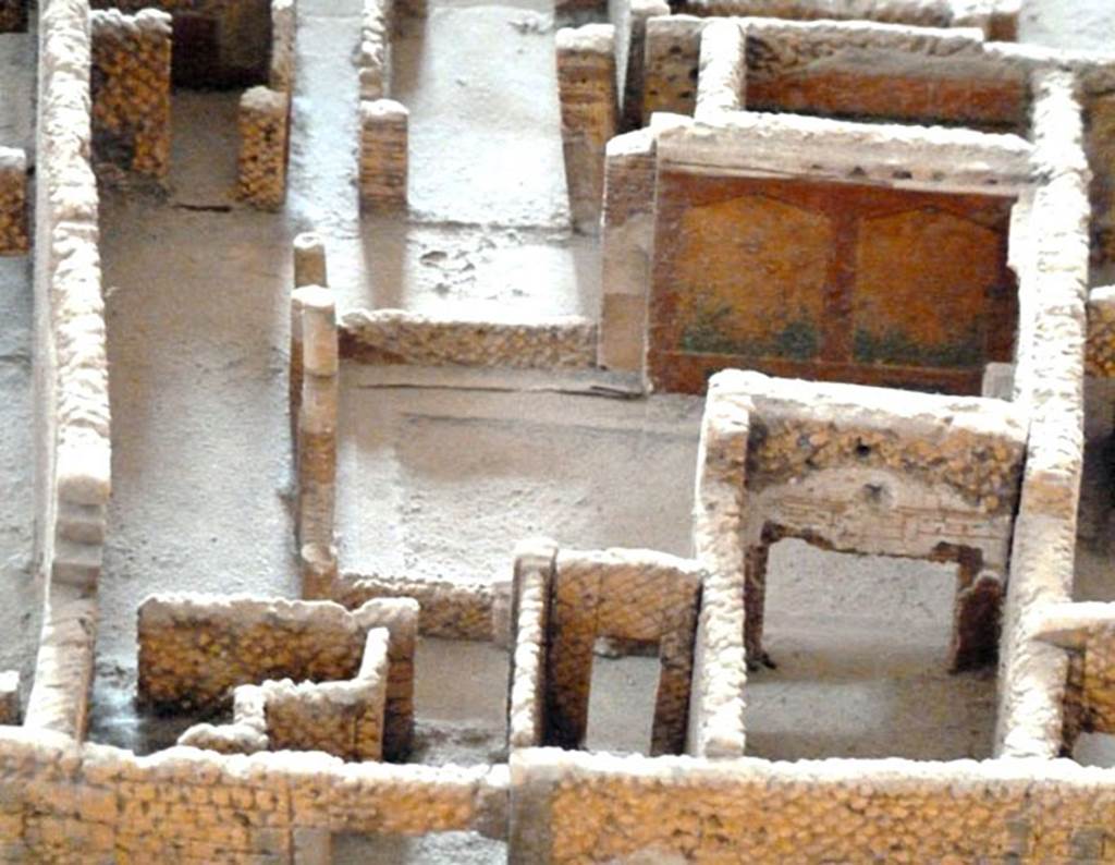 VI.2.22 Pompeii. May 2010. Looking east from rear entrance in Vicolo di Narciso, into peristyle area with painted garden wall.
In the lower part of the photograph, can be seen the entrance corridor at VI.2.15, left of centre.
On the right of centre is a cubiculum with a doorway onto the west portico, and on the right of it is the large triclinium.
Model as viewed in Naples Archaeological Museum.