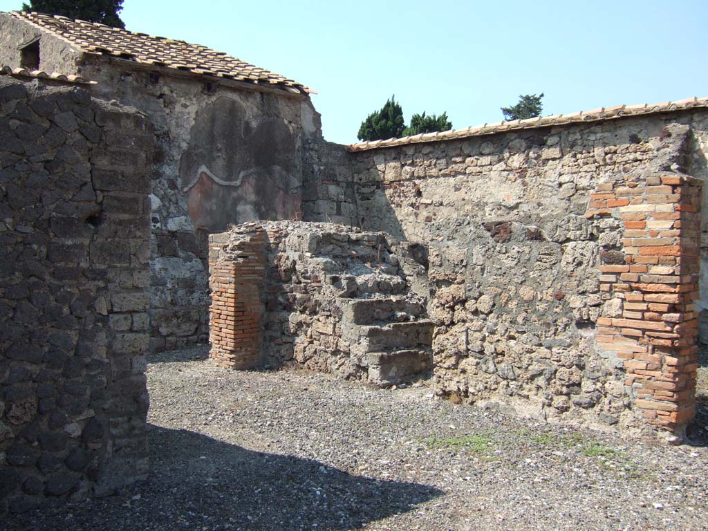 VI.2.24 Pompeii. September 2005. Looking north-west across open tablinum towards steps to upper floor. 
At the rear of the steps, the painted west wall of the oecus can be seen.