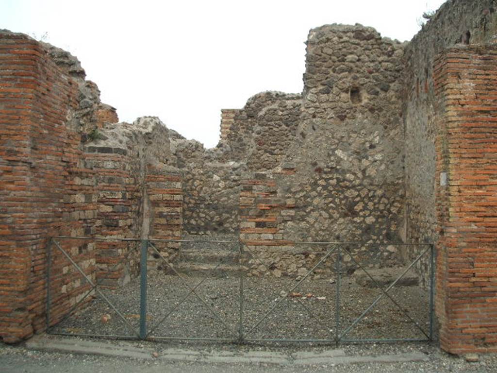 VI.3.4 Pompeii. May 2005. Entrance doorway, looking east. In the north wall (on left) is a doorway into a room with window. In the east wall there are two steps to a rear room. In the south-east corner there is a base for stairs to an upper floor.
