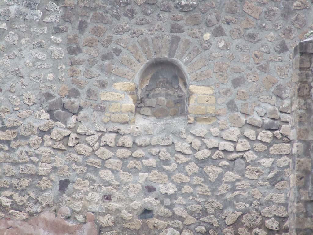 VI.3.7 Pompeii. December 2007. Niche in east wall of garden area.
According to Jashemski, the garden, excavated in 1809, at the rear of the tablinum, had a portico on the west supported by a brick pillar.
There was a Lararium niche on the east wall, with a shrine painting below, before which stood a masonry altar.
The large room on the right (south) of the garden gave a fine view of the garden.
A marble head of a lion with mouth bored for use as a fountain was found in the house.
See Jashemski, W. F., 1993. The Gardens of Pompeii, Volume II: Appendices. New York: Caratzas. (p.124)