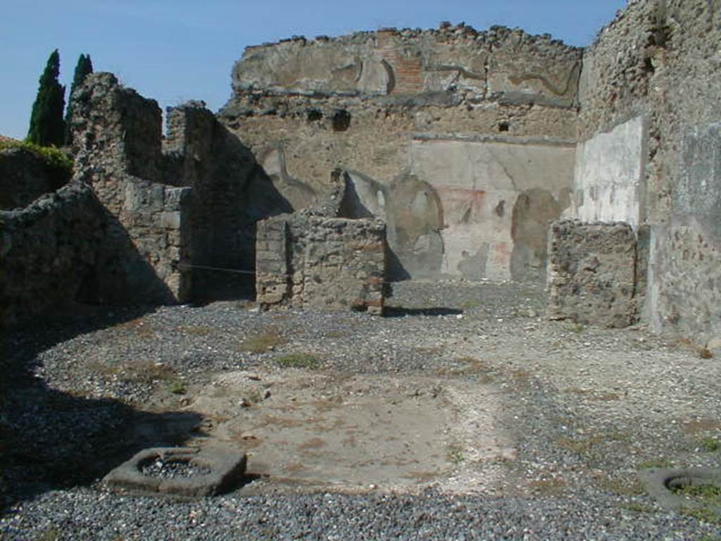 VI.5.13 Pompeii. September 2004. Looking north across atrium towards rear rooms.
According to Bonucci, 
“The room on the left would have been a bedroom; the larger one on the right was the tablinum, which was also forced to serve as the dining room, because no other triclinium was found. Found in the tablinum which was paved in mosaic, the remains of a painting representing Phryxus and Helle, above two figures, one standing the other seated, and higher still a pretty stucco moulding”. 
See Bonucci, C, 1827. Pompei descritta, p. 103.
According to Breton, “At the rear of the tablinum, paved in mosaic, was an almost erased painting which represented Phryxus and Helle”.
See Breton, Ernest. 1855. Pompeia, decrite et dessine: Seconde edition . Paris, Baudry, p. 256-7.
According to Fiorelli, found in the atrium were two paintings.
One showed Ulysses and Circe, the other Achilles being recognised by Ulysses at the court of Lycomedes.
In the tablinum, two badly damaged paintings were found. One of Phryxus and Helle, the other of Adonis wounded. 
There were also figures in the middle of the ornately painted architecture, Helbig’s numbers 979, 994, 1001. 
See Pappalardo, U., 2001. La Descrizione di Pompei per Giuseppe Fiorelli (1875). Napoli: Massa Editore. (p54)
According to Helbig, found in the atrium were Odysseus (Ulysses) and Circe (1329), Achilles at Skyros, (1299), and Seasons (979, 994 and 1001) 
In the tablinum, Phryxus 1252, and Adonis, 343, were found, and above was Hermes 360b,
See Helbig, W., 1868. Wandgemälde der vom Vesuv verschütteten Städte Campaniens. Leipzig: Breitkopf und Härtel.
According to Jashemski, Fiorelli thought that the atrium had a space in the middle for growing plants.
She said that Overbeck-Mau thought the planting beds were in the top of a low wall that enclosed the implvium.
There were two cistern mouths near the impluvium.
See Jashemski, W. F., 1993. The Gardens of Pompeii, Volume II: Appendices. New York: Caratzas. (p.126)