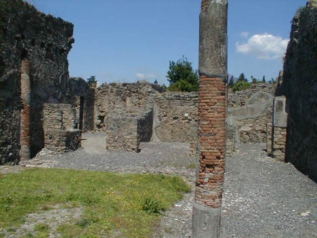VI.5.14 Pompeii. May 2004. Looking north along east portico towards rear rooms on north side. The lararium can be seen on the left.