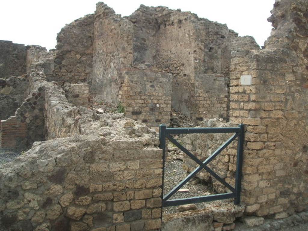 VI.6.7 Pompeii. May 2005. Looking west to rooms on west side of atrium of VI.6.7 across the entrance at VI.6.6. On the left, at the rear, can be seen the remains of a passageway leading to the kitchen and latrine.