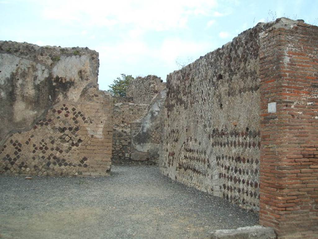 VI.6.21 Pompeii. May 2005. Looking north along east wall of shop towards doorway in north-east corner into VI.6.17. According to Stefani, this was a large corner sales shop for the bakery at its rear. On the west wall was a lararium painting with serpent, on the facing wall was a supposed “cross” in stucco. See Stefani, G. (2005): Pompei. Un Panificio: in Cibi e Sapori a Pompei e dintorni, (p.139).
