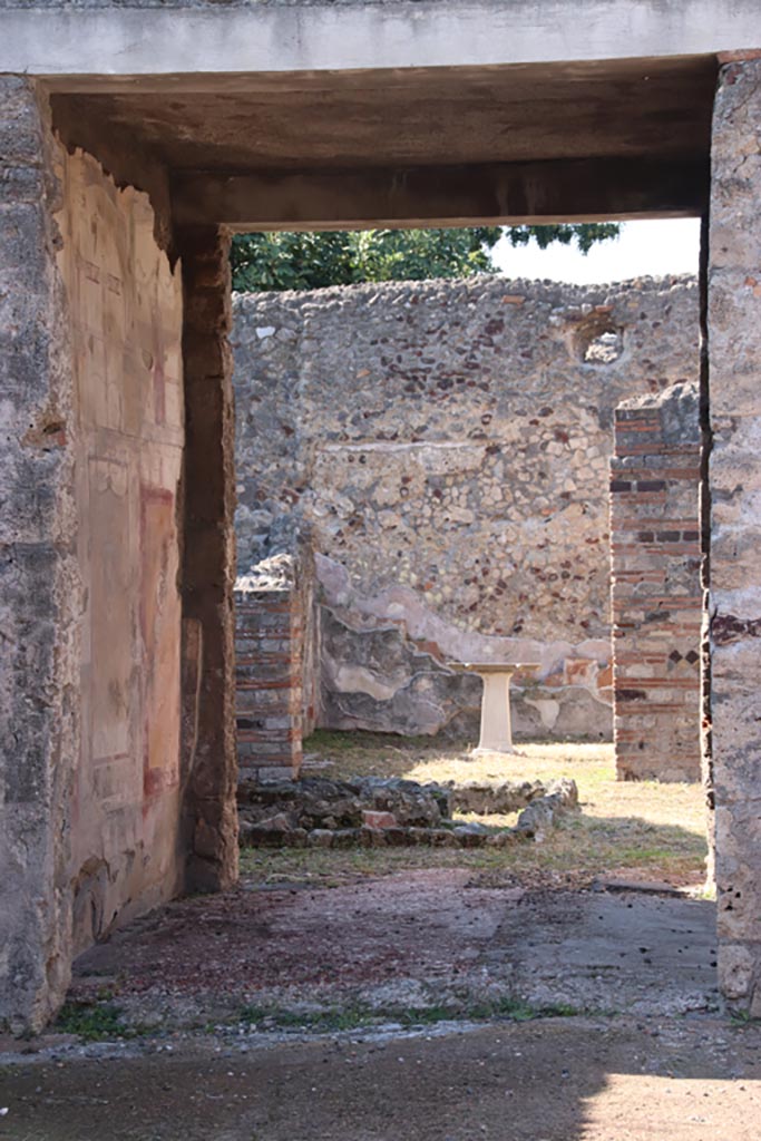 VI.7.23 Pompeii. October 2022. 
Looking west through tablinum towards remains of pyramidal fountain in courtyard, and triclinium with table.
Photo courtesy of Klaus Heese.