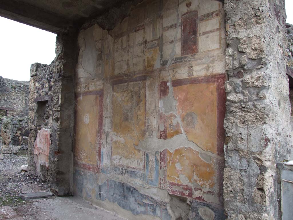 VI.7.23 Pompeii. December 2006. North wall of tablinum, looking west.  
On the left at the rear of the tablinum, the painted remains of the north wall of the courtyard can still be seen.
The wall had a window into a room, with its doorway in the corridor leading to the garden area.
