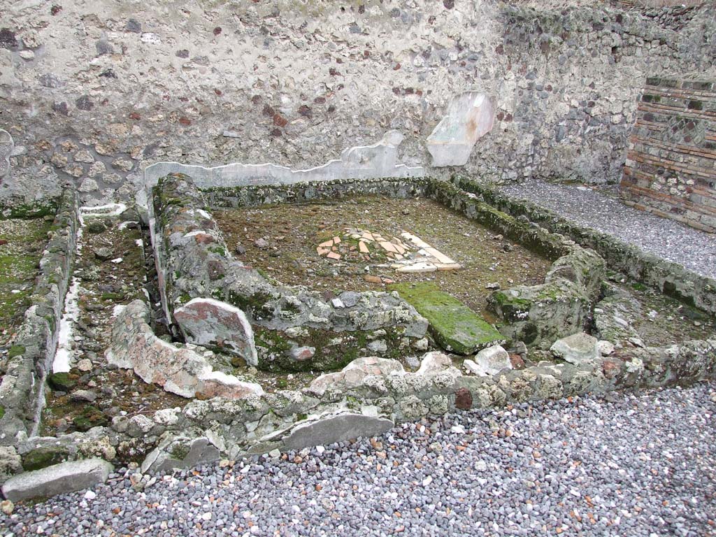 VI.7.23 Pompeii. December 2006. Remains of pyramidal fountain in courtyard.  
According to Garcia y Garcia, this area was badly damaged due to the bombing during the night between the 14th and 15th September 1943. 
The beautiful pyramid-shaped fountain was destroyed together with the partial destruction of the south wall including the beautiful garden painting with a painted statue of Diana. This was painted on the wall behind the fountain. Also destroyed were the dividing walls of the rooms on the west side of the area.
The damage was partially restored in 1976.
See Garcia y Garcia, L., 2006. Danni di guerra a Pompei. Rome: L’Erma di Bretschneider. (p.76)
See Jashemski, W. F., 1993. The Gardens of Pompeii, Volume II: Appendices. New York: Caratzas. (p.130-32).