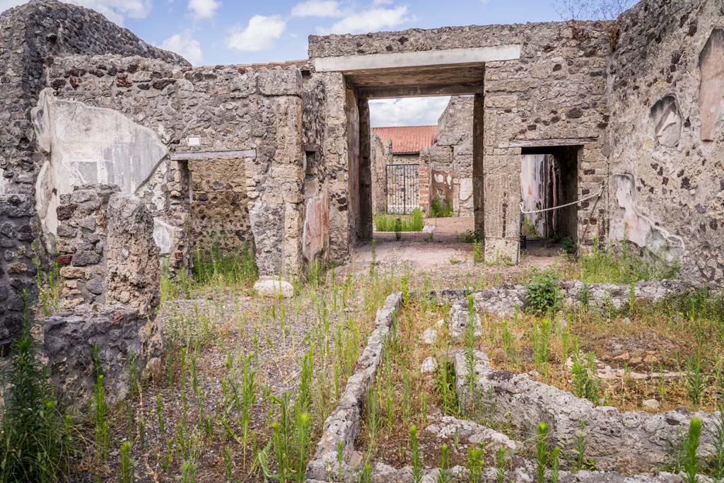 VI.7.23 Pompeii. July 2021. 
Looking east across remains of pyramidal fountain in courtyard, towards doorway to cubiculum with window (left), tablinum, and corridor.
Photo courtesy of Johannes Eber.