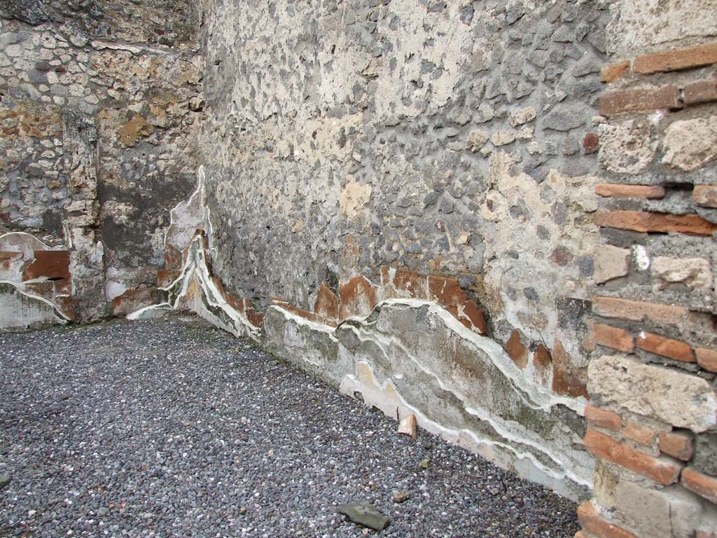 VI.7.23 Pompeii. December 2006. Walls showing remains of many levels of painted plaster in triclinium.
Looking west along north wall of triclinium. The west and north walls were faced with tegulae mammatae.