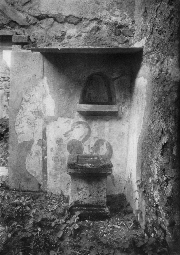 VI.7.23 Pompeii. c.1930?  Kitchen, north wall with niche and painting of serpent.
See Boyce G. K., 1937. Corpus of the Lararia of Pompeii. Rome: MAAR 14. (p. 48, no. 167, and Pl. 11,1)