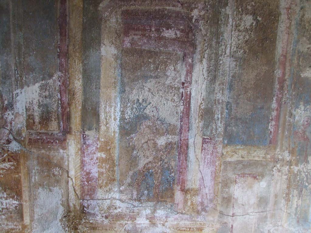 VI.7.23 Pompeii. December 2006. Cubiculum. North wall, east end. Marsyas with nebride (fawn-skin).
According to Caso this is the naked figure of Marsyas.
He is covered only on the shoulders by the nebride (skin of a fawn), the fluttering edges of which are seen behind his back. 
In his hand is the tibia (double flute) thrown away by Athena.
See Caso L., in Rivista di Studi Pompeiani III, 1989, p. 121-2.
