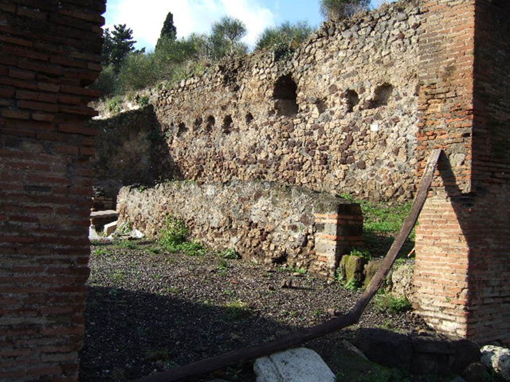 VI.7.26 Pompeii. December 2005. Looking west from entrance. According to Winsor Leach, this entrance led into a stable yard located under the wall, with a hay-loft above. A stair lead to a hayloft and the opening through which the hay was loaded can be seen. See Leach, E.W: The Social Life of Painting in Ancient Rome and on the Bay of Naples.