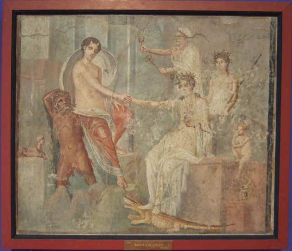 VI.9.1 Pompeii. Painting of the Arrival of Io at Canopus. From a room north of the atrium. 
Io is depoasited on the rocks at Canopus carried by a river god, probably the Nile. She is being greeted by Isis. Behind Isis stand two figures, possibly Mercury and a priest. The small Harpocrates is to the right of the painting with his hand to his lips in the gesture of silence. To the left of the river god is a sphinx, and under Isis foot is a crocodile and a cobra. Now in Naples Archaeological Museum. Inventory number 9555. The house was named after this painting. See Zahn in BdI 1831 p. 18. See Helbig, W., 1868. Wandgemälde der vom Vesuv verschütteten Städte Campaniens. Leipzig: Breitkopf und Härtel. (139).