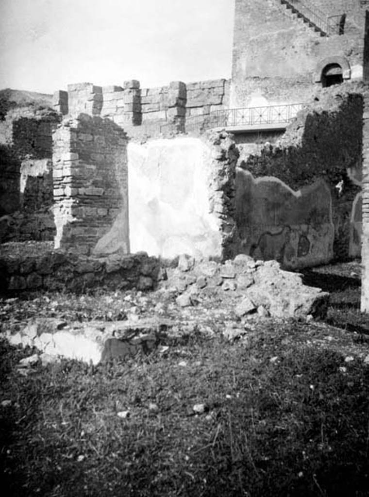 6.9.1 Pompeii. W660. Looking north-west across the walkway (room 4) on north side of garden 18. On the right, through the open doorway, are the remains of the west wall of room 11, the large oecus.
Photo by Tatiana Warscher. With kind permission of DAI Rome, whose copyright it remains. 
See http://arachne.uni-koeln.de/item/marbilderbestand/231236 
According to Warscher, this photograph showed the north-west corner of the Xystus where one could see the remains of a podium, the channel, and the mouth of the cistern.
In the background was the triclinium “L”.
See Warscher, T, 1938: Codex Topographicus Pompejanus, Regio VI, insula 9: Pars prima, (no.23), DAIR, Rome.