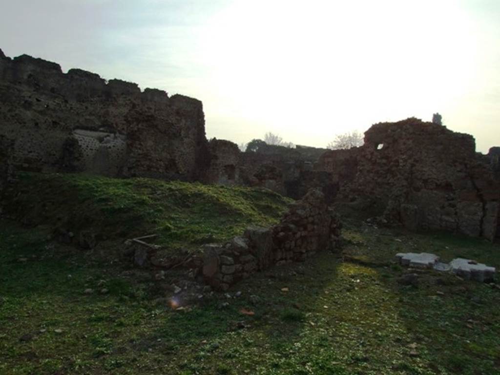VI.9.1 Pompeii. December 2007. Looking south-west from garden area 18, across site of the spacious room 15, probably a large triclinium. This would be under the large mound of earth topped with green grass. The doorway to the atrium, with the remains of the arca, can be seen, right of centre.